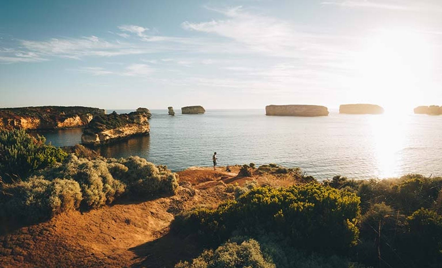 person looking out to sea on the coastline