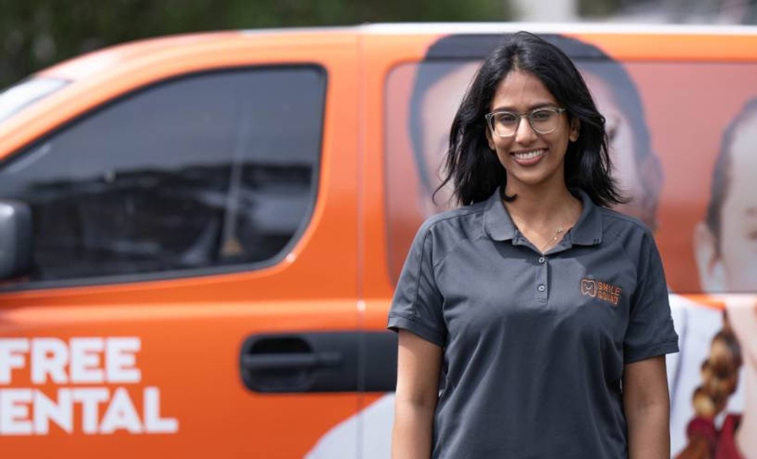 Smile Squad staff smiling in front of van