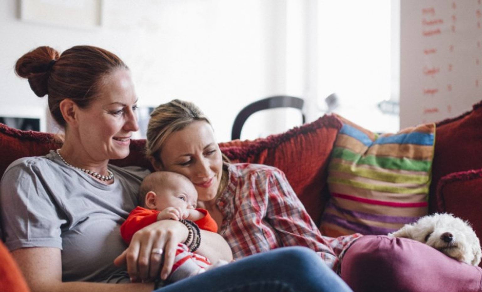 two women on a couch holding a baby
