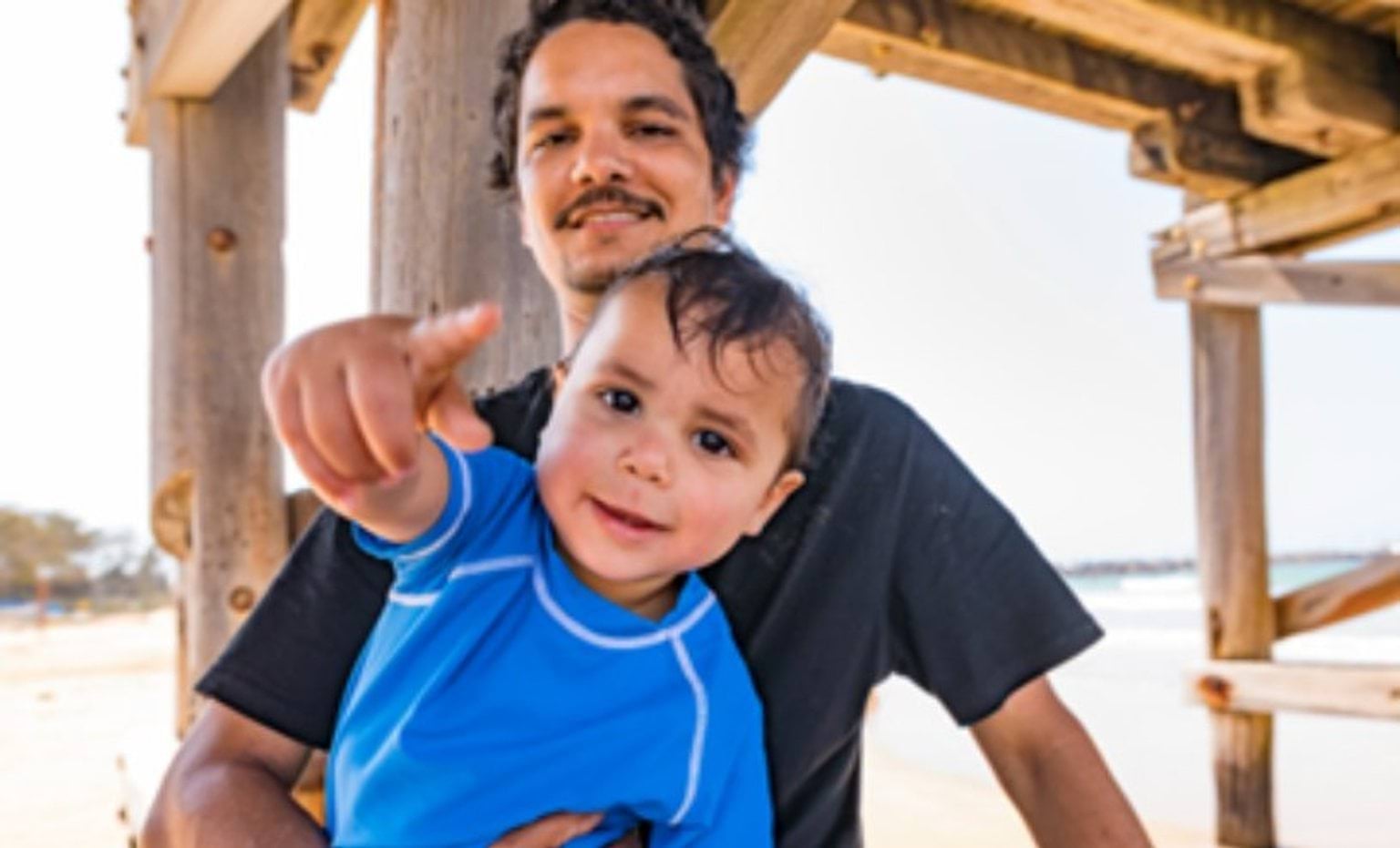 young child and man under a pier