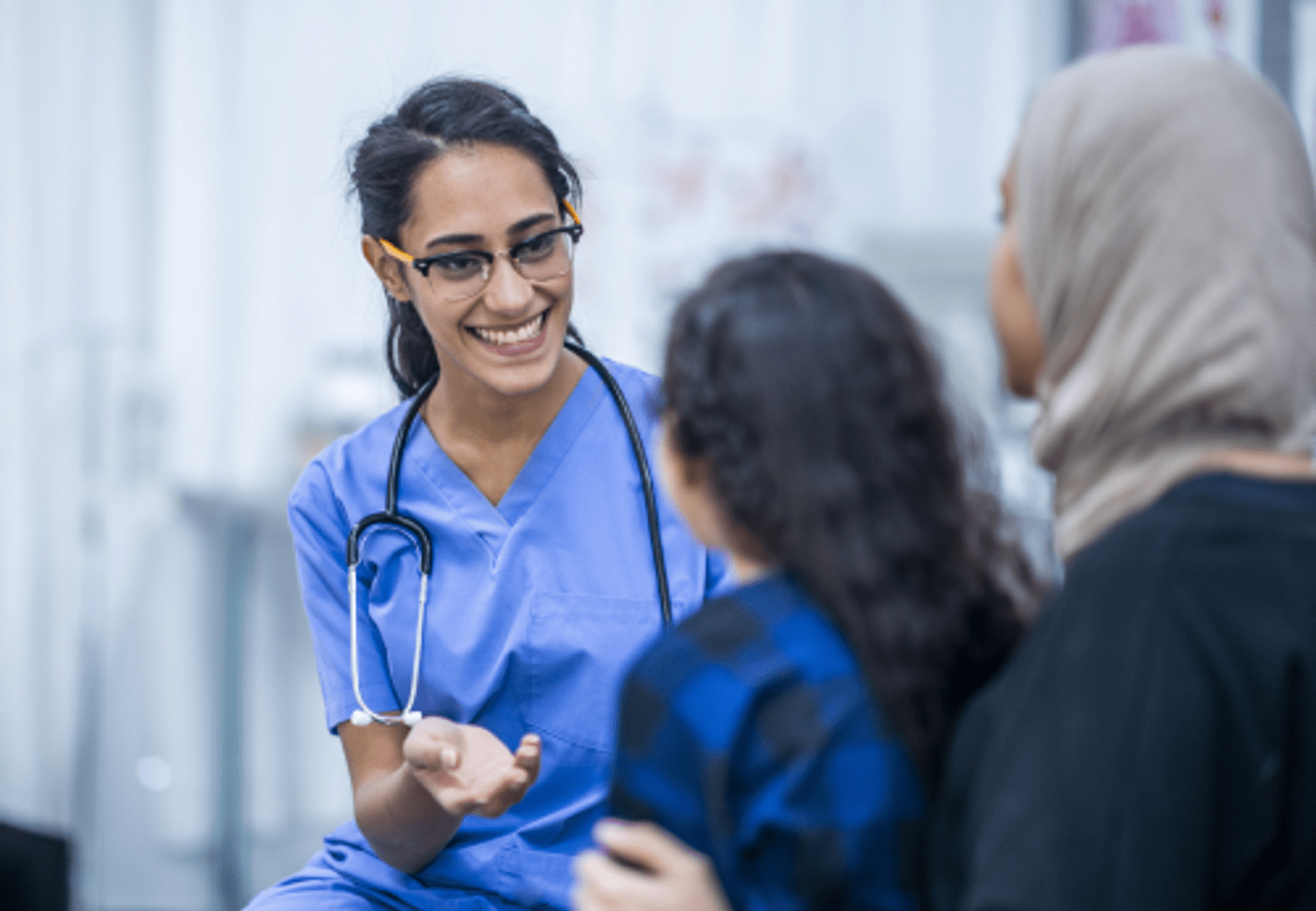Mother and daughter chat to smiling health professional