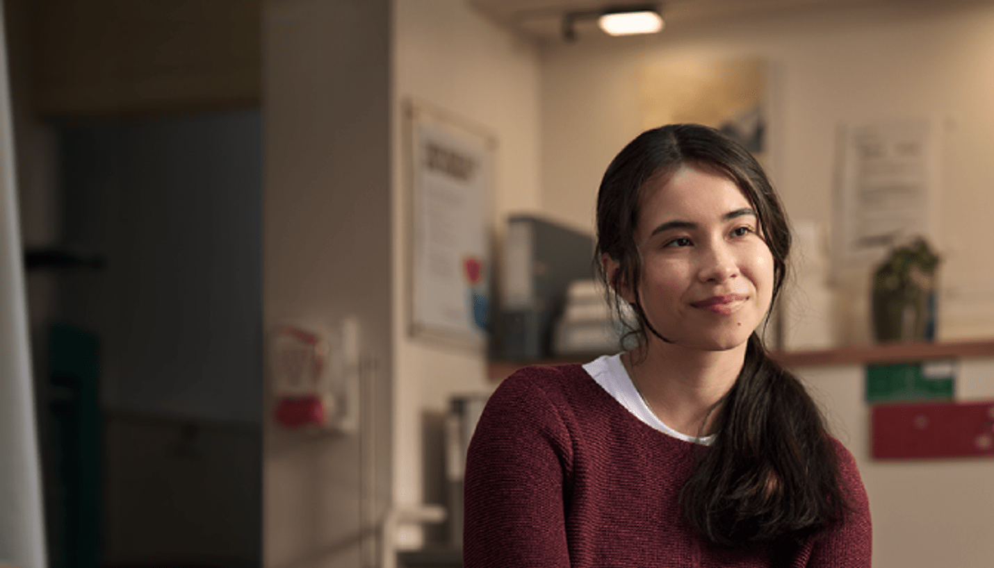 A young woman waits in a consulting room