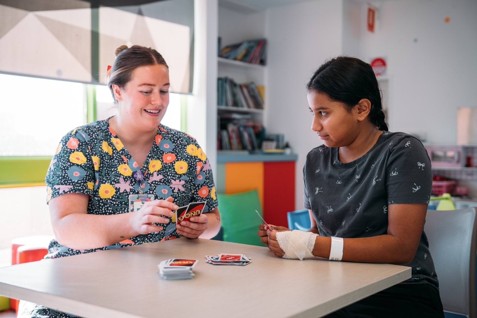 Two healthcare workers playing uno on a break